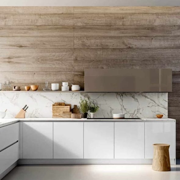 a kitchen with white cabinets and wood walls